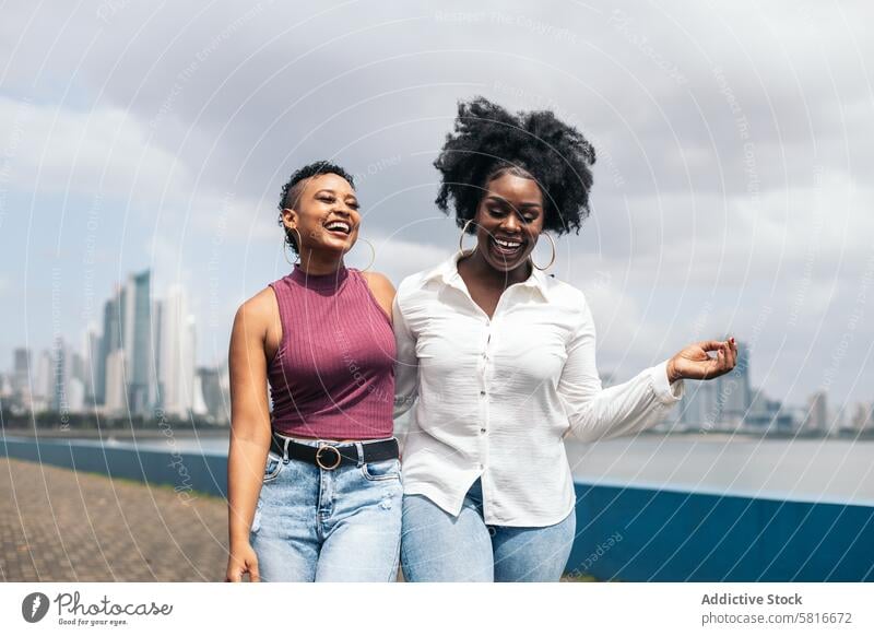 Women talking and laughing walking along the seafront in Panama City happy young summer woman female outdoors people leisure lifestyle joyful looking spring