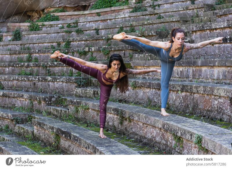 Focused women standing in Hand to Toe pose and doing yoga flexible practice balance hand to toe pose hasta padangusthasana stretch together female stress relief