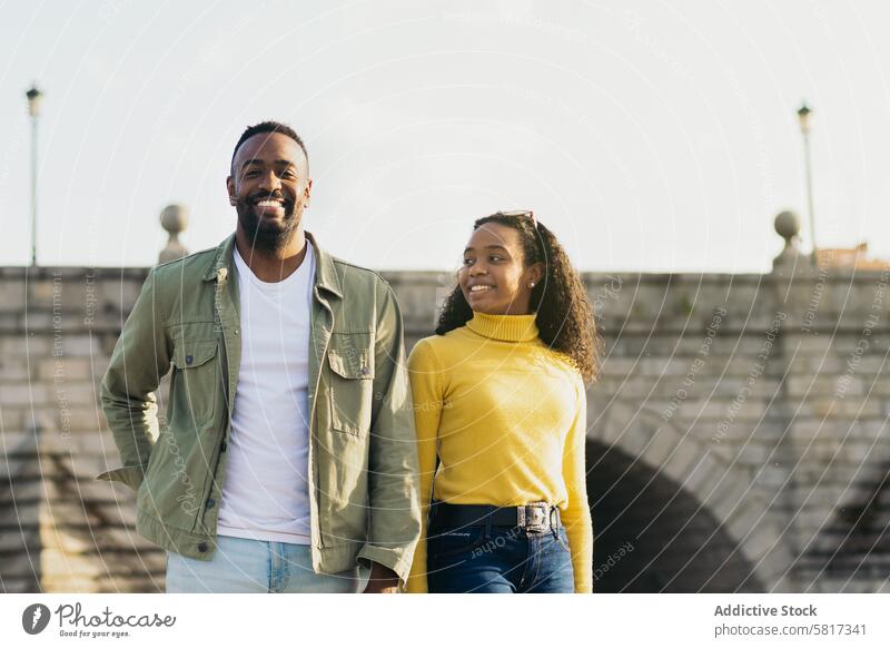 smiling african american couple portrait in front of a bridge female woman happy together black city people twenties front view men horizontal friends 20s