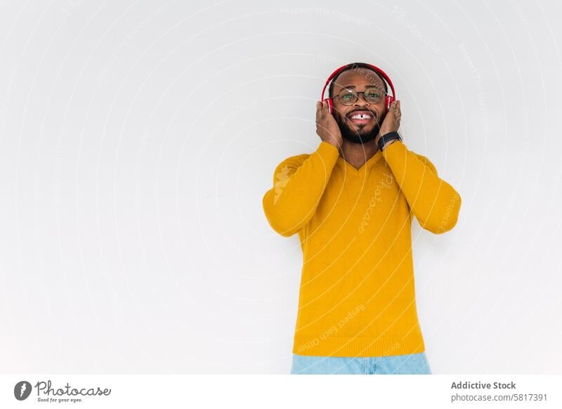 Black man listening to music in headphones smile using relax rest chill song delight meloman male happy black glad african american enjoy teeth gap device