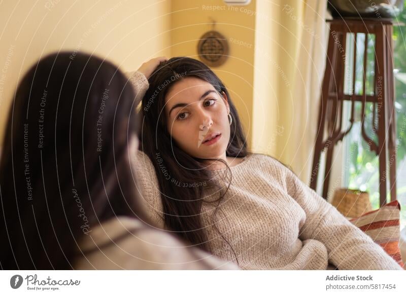 Young woman talking with worried face with her mother sitting on the sofa at home. daughter family bread fruit giving together happy food kid girl childhood