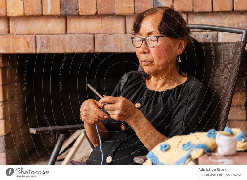 Serenity in stitches. Elderly Asian woman knits at home. active aging art and craft artistic artistic expression authenticity care cozy home craftsmanship