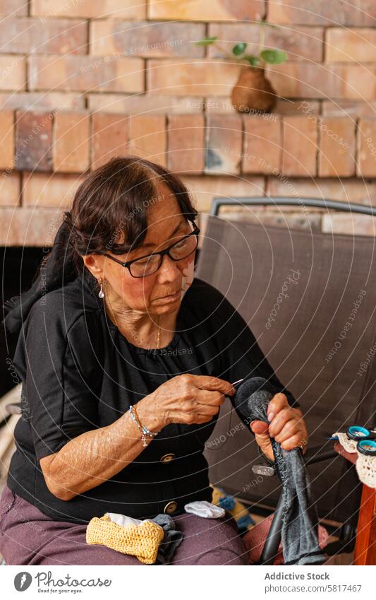 Yarn dreams: Elderly Asian woman's creative escape. active aging art and craft artistic artistic expression authenticity care cozy home craftsmanship creation