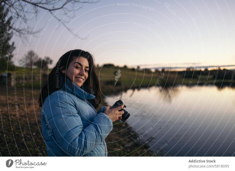 Photographer woman taking photos of a lake at sunset nature water sky female travel lifestyle landscape view scene outdoors calm peace serene winter cold coat