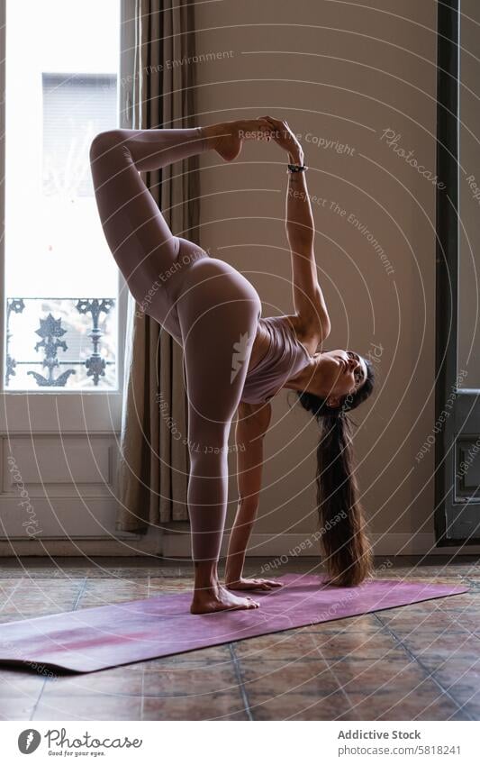 Woman performing Revolved Half Moon Bow pose on yoga mat woman stretch revolved half moon bow talent wellness vitality twist balance home practice flexible