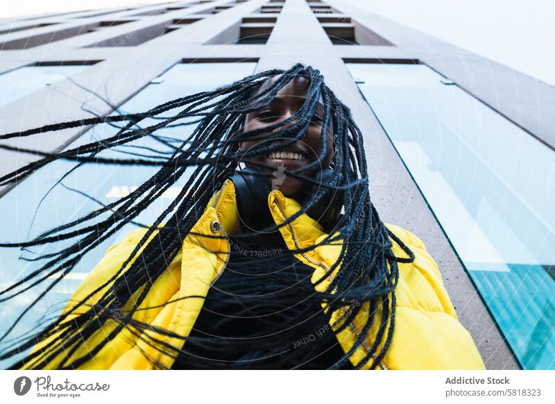 Black woman against skyscraper in city street downtown style modern building urban young female braid high rise exterior ethnic black african american