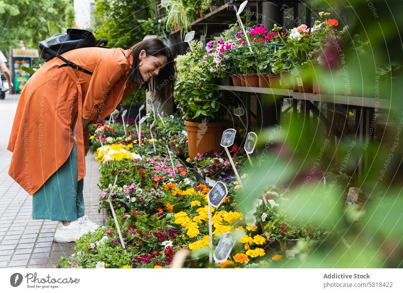 Cheerful woman choosing flowers in garden center market choose bloom pick customer city female plant fresh organic gardener aroma grow growth potted flowerpot