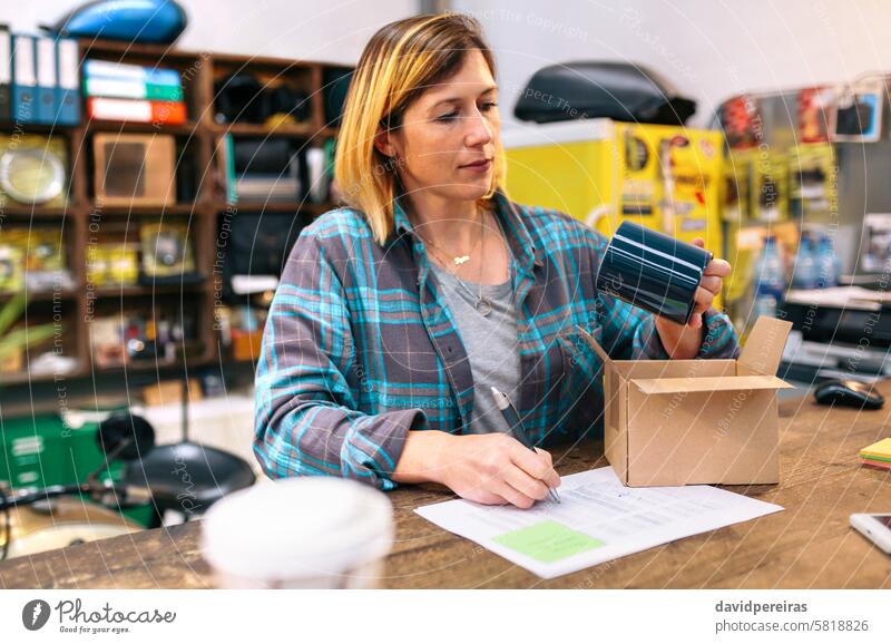 Portrait of blonde woman entrepreneur checking product received by courier to sell in local store portrait businesswoman new selling shop female review