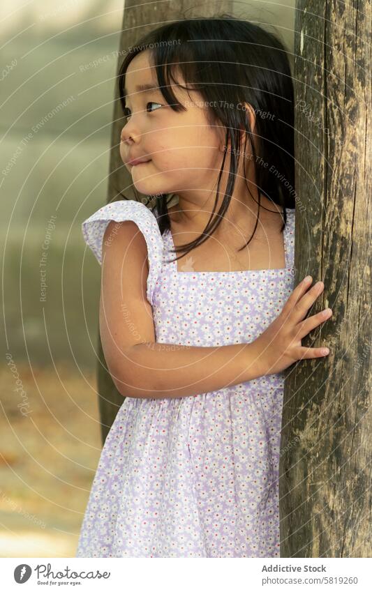 Asian toddler girl in a playful summer dress outdoors child asian vacation europe tree thoughtful childhood park travel leisure family tourist visitor