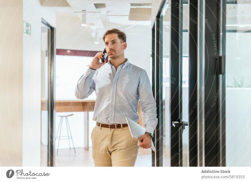 Busy professional walking and talking in coworking space businessman phone office confident pacing communication corporate environment workspace attire smart