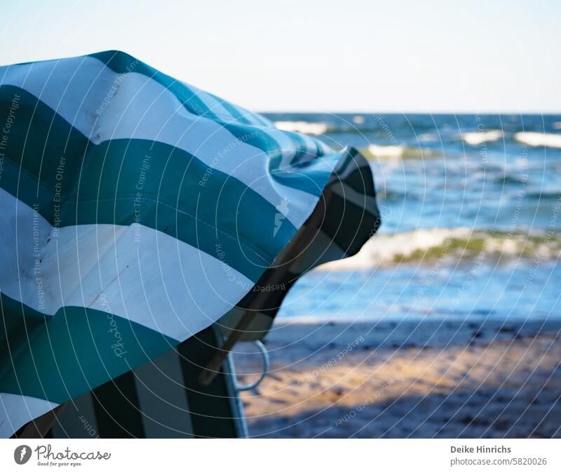 Green and white striped beach chair on the Baltic Sea beach. Summer vacation Nature Strang Beach chair Sandy beach free time Relaxation Ocean holidays Sun Water