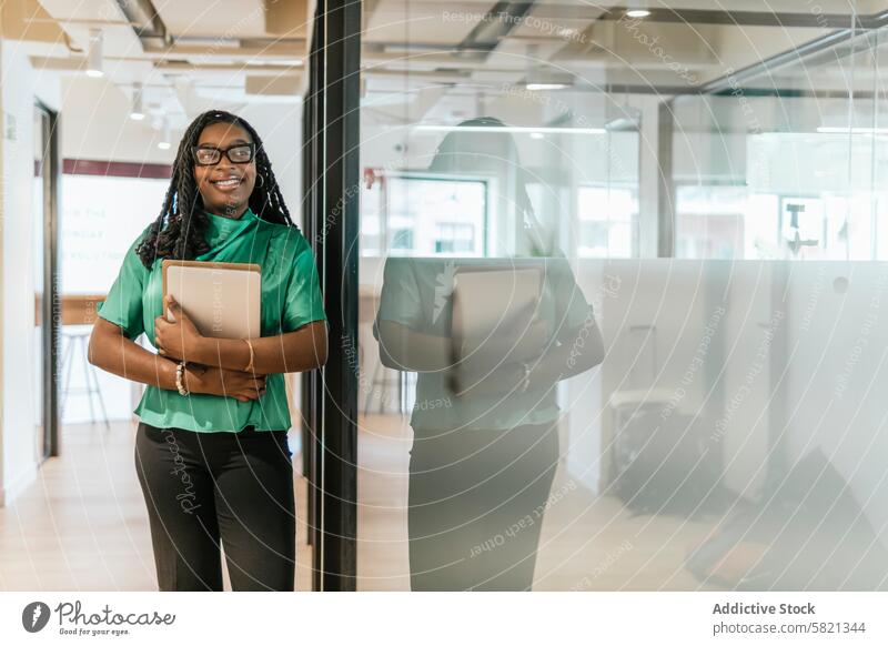 Confident professional at modern coworking space woman office business laptop confident standing holding ready corporate environment attire smart green shirt