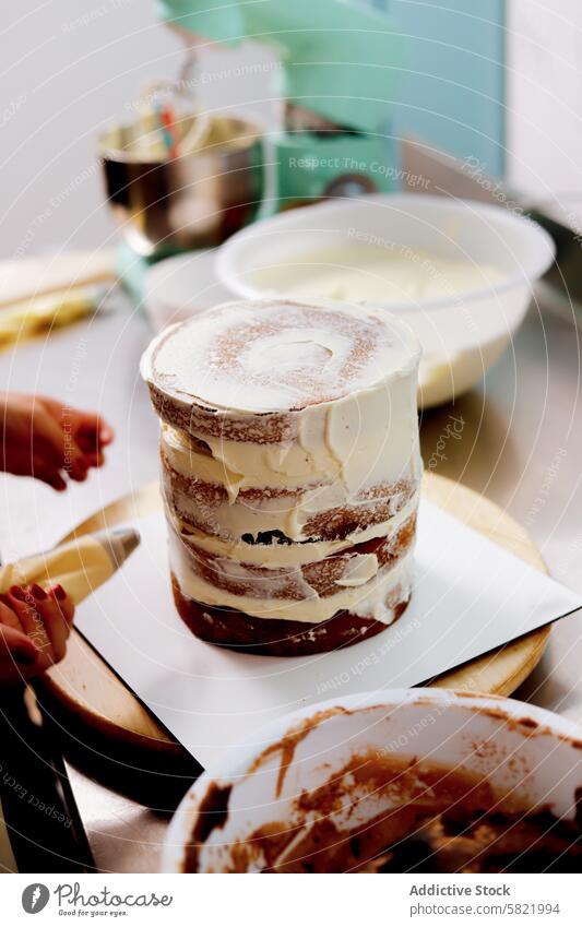 Assembling a layered cake with cream frosting baker dessert baking utensil ingredient pastry kitchen bowl spatula homemade confectionery bakery sweet food