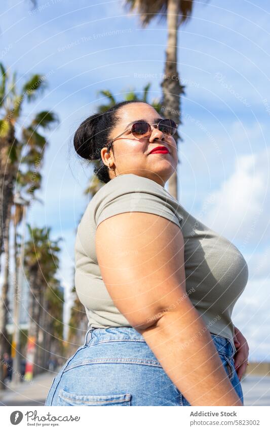 Confident Woman Enjoying Summer Day in Barcelona woman summer barcelona sun palm tree casual wear confident vibrant bliss basking outdoor daytime fashion style