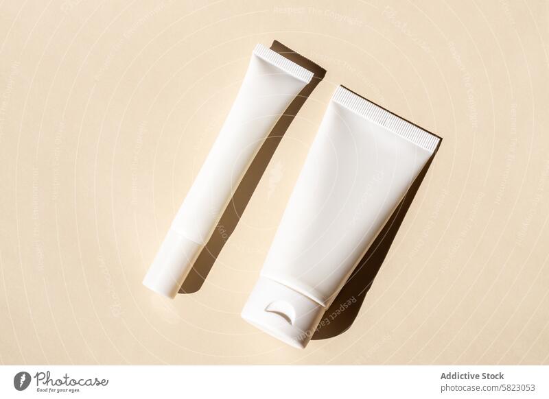 Skincare tubes with artistic shadow on neutral background skincare cosmetic beige product packaging minimalistic elegance soft light beauty cream lotion