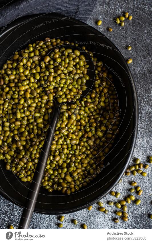 Close-up of raw organic mung beans in a pan skillet spoon dark close-up rustic legume green heap cooking ingredient nutrition healthy diet vegan vegetarian food