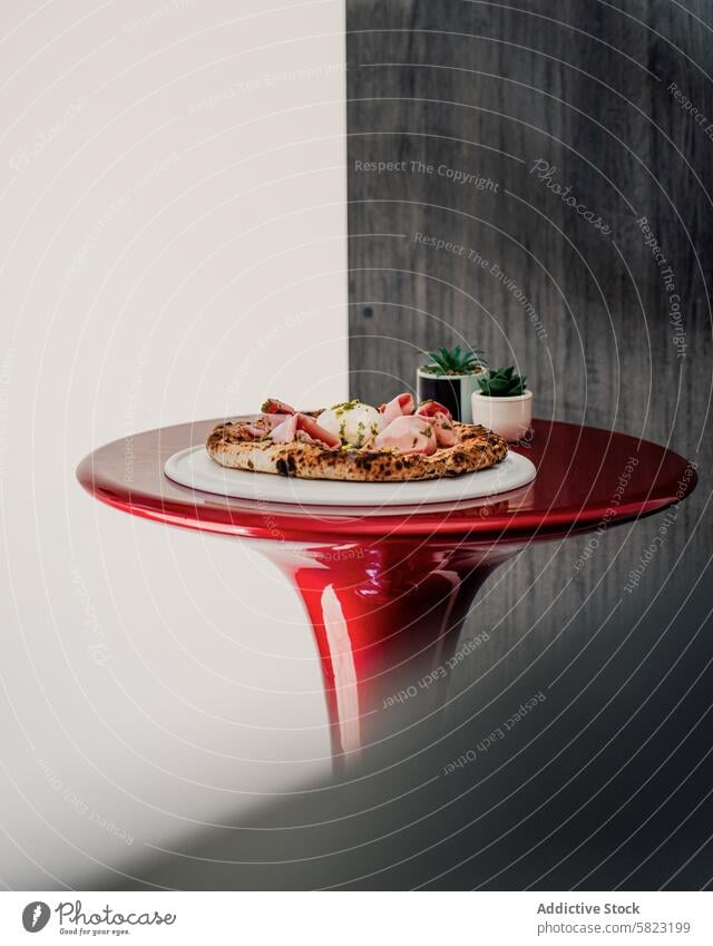 Artisan pizza on a red table in a modern pizzeria setting artisan food restaurant dining italian cuisine topping tomato cheese meal lunch dinner gourmet crust