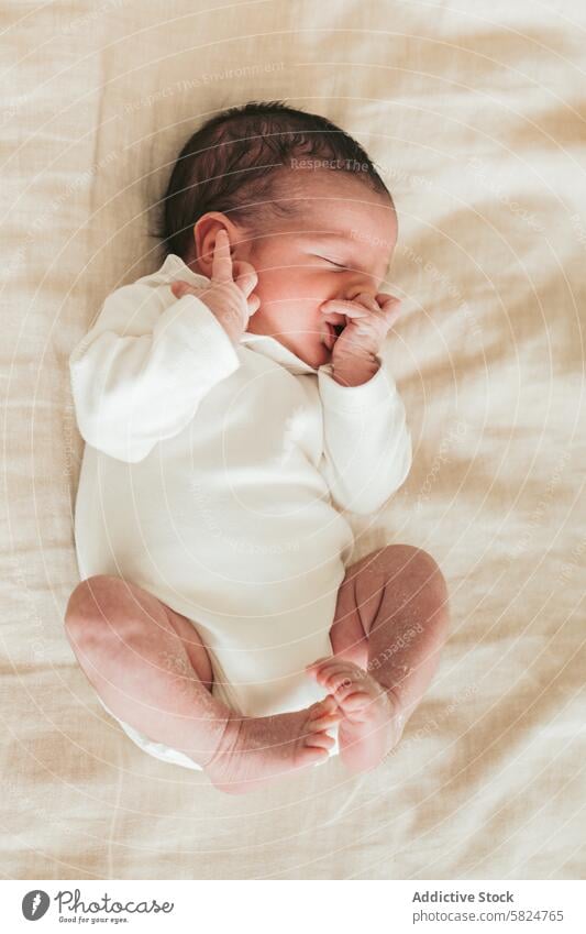 Newborn baby resting peacefully on a soft blanket newborn sleep infant cute cozy gentle touch face curled beige clothed tiny delicate nap comfort serene warmth