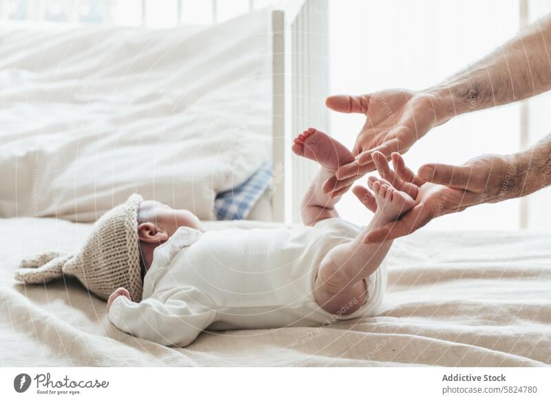 Gentle touch: Baby's first moments with parent baby infant tender gentle hands feet interaction bonding blanket soft care love newborn family delicate