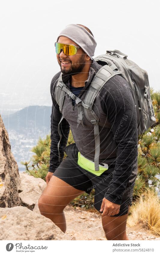 Hiker training on a mountain trail hiker male backpack sports gear sunglasses rocky path outdoors adventure fitness active lifestyle trekking exercise nature