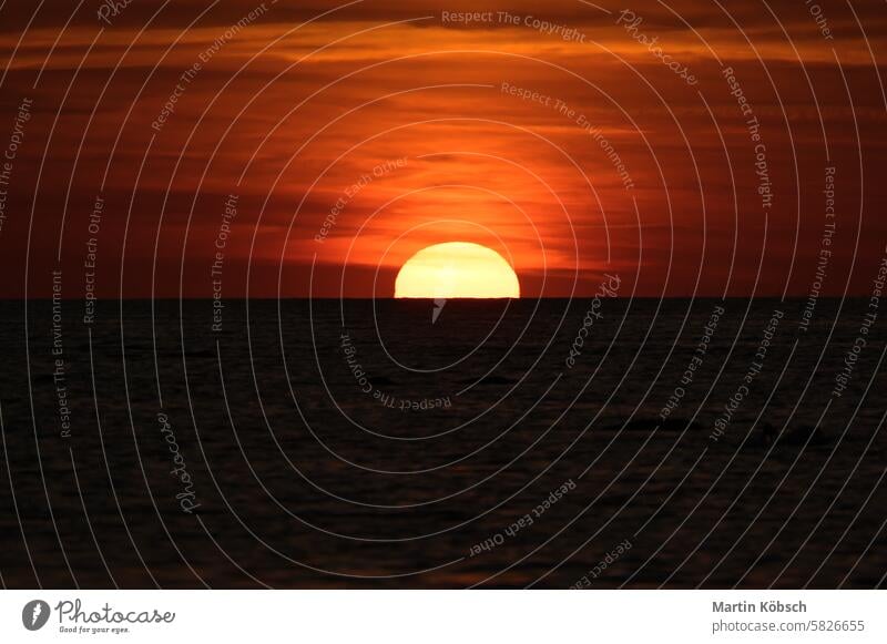 Sunset on the horizon of the Baltic Sea. Orange sun sinks into the water. Romantic sunset sunbeams sunshine reflection wavy coast romantic travel nature Swarm