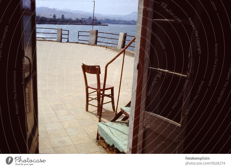 Chair on terrace by the sea Terrace Old Ocean Vantage point Door entrance outlook Southern Mediterranean vacation Siesta pause Relaxation free time on one's own