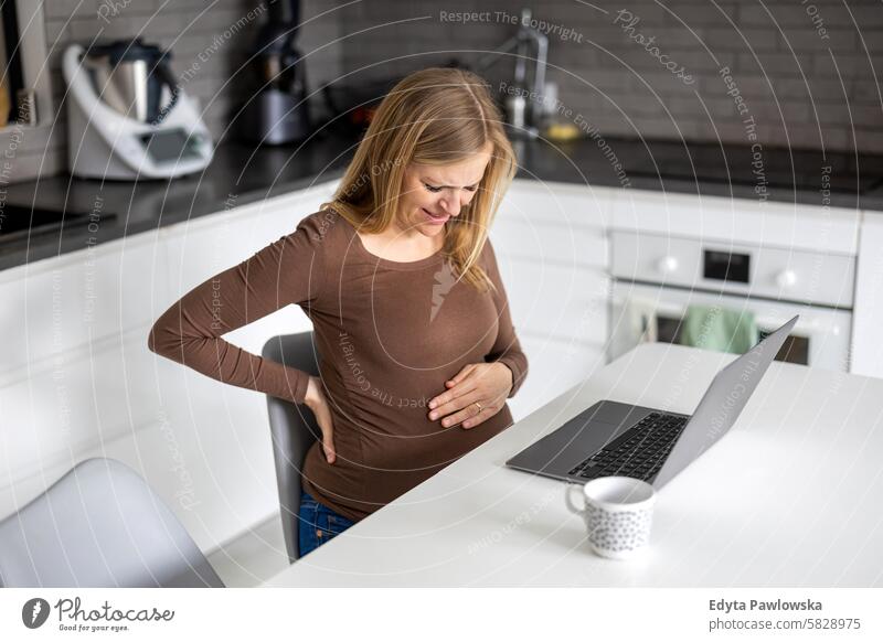 Pregnant woman working with laptop at home pregnancy pregnant adult anticipation awaiting baby belly birth body care caucasian child expectant expecting