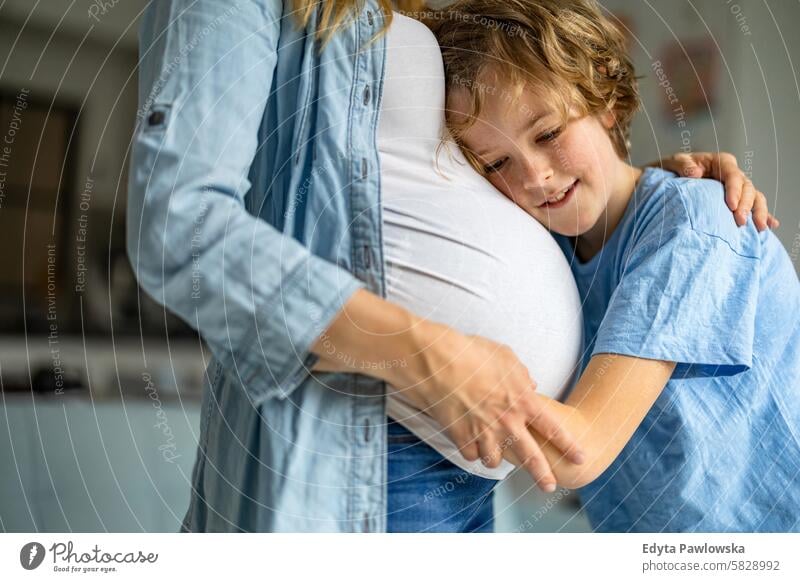 Little boy with his pregnant mother at home pregnancy adult anticipation awaiting baby belly birth body care caucasian child expectant expecting expectation