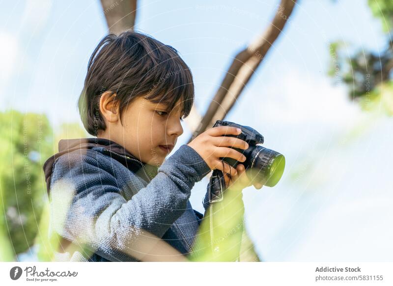 Young boy exploring nature with camera on a spring weekend photography outdoor exploration child grandchild adventure trees sky daylight hobby interest youthful