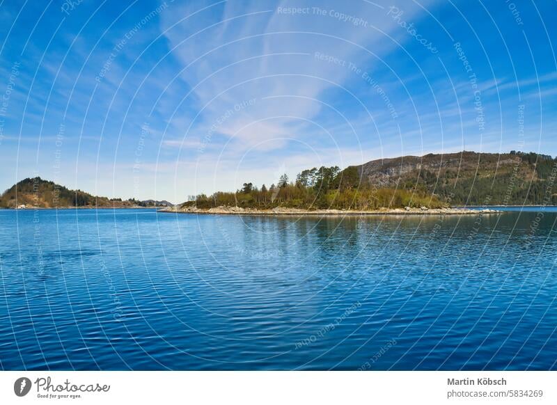 Island with rocks and trees in the fjord in front of the open sea in Norway. Fjord sunset mountain wilderness nature nordic panorama romantic fresh water sky