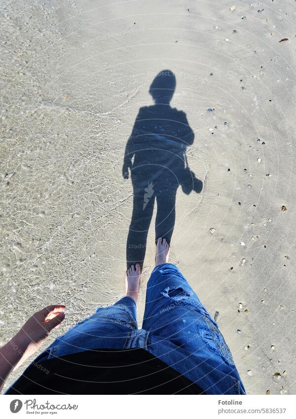 I walk barefoot along the beach on Heligoland. My shadow reveals that I have my camera with me and am looking for a motif. Shadow Light and shadow Shadow play