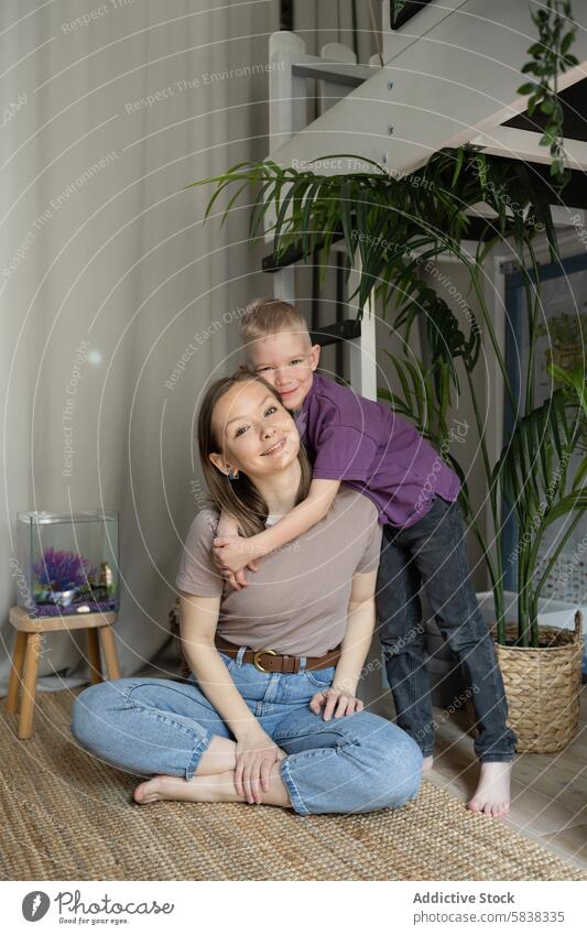 Mother and son bonding with a fish tank at home mother aquarium family time aquatic life smiling embracing indoor leisure activity looking at camera child