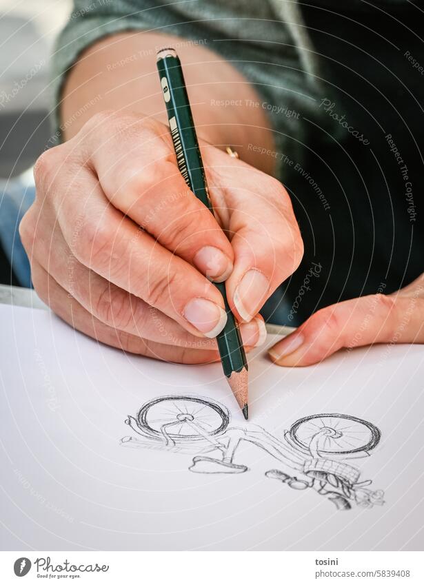 Woman draws a bicycle on paper with a pencil Art Hand Draw Fingernail Pencil Creativity Paper Artist Leisure and hobbies Close-up Painter Colour photo Drawing