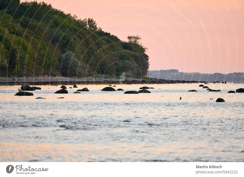 Sunset, illuminated sea. Sandy beach in the foreground. Light waves. Baltic Sea sunset sunbeams sunshine reflection coast ocean travel romantic Sand beach