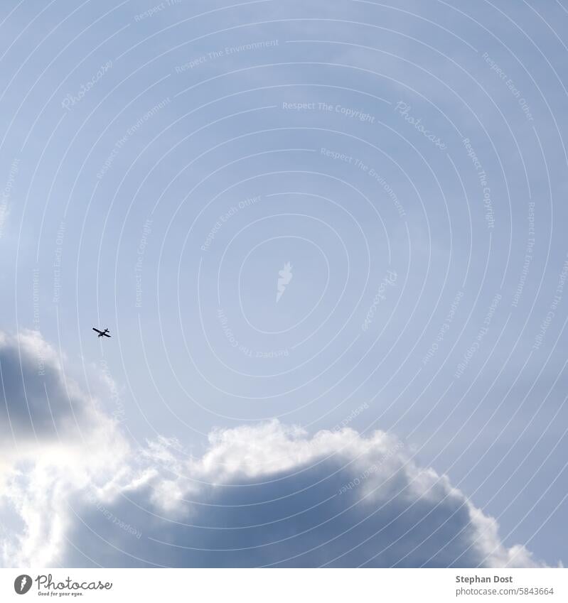 Small airplane in a cloudy sky small plane Two-seater Sky height Atmosphere Blue Clouds distance Flying Freedom Haze Tall Light Visual spectacle Shadow play