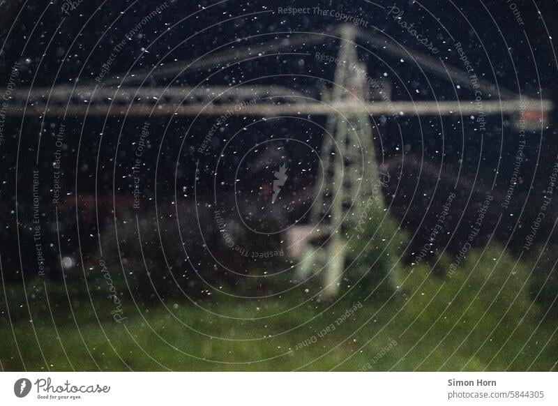 Falling raindrops in front of a blurred crane To fall Night Rain points Drops of water light points Wet Storm Weather Rainy weather Bad weather Black Crane