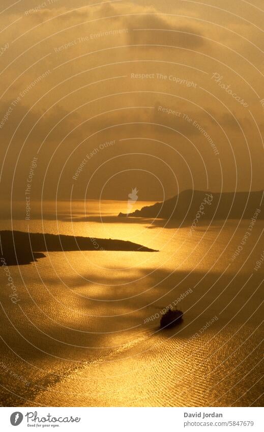 golden sunset with rain clouds on Santorini in the Mediterranean, Aegean Sea Sunset Sunset sky Rain during a golden sunset shining sea golden ocean