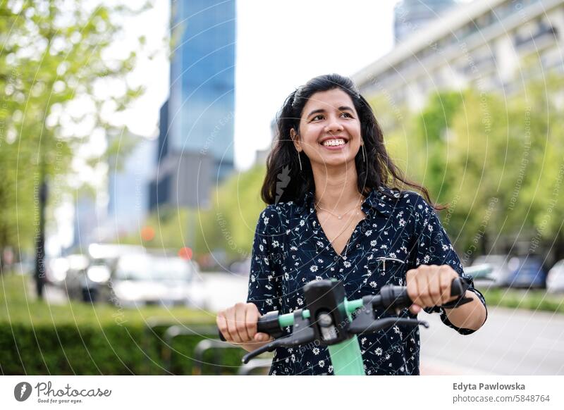 Portrait of happy woman with electric scooter in the city Indian real people fun summer enjoying street travel outdoors urban adult young adult attractive