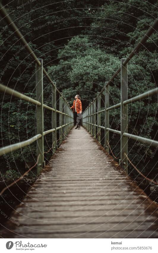 Standing on the bridge Human being Woman Shirt Hiking Bridge look stop rail Wooden bridge Steel Green by oneself Lonely tranquillity