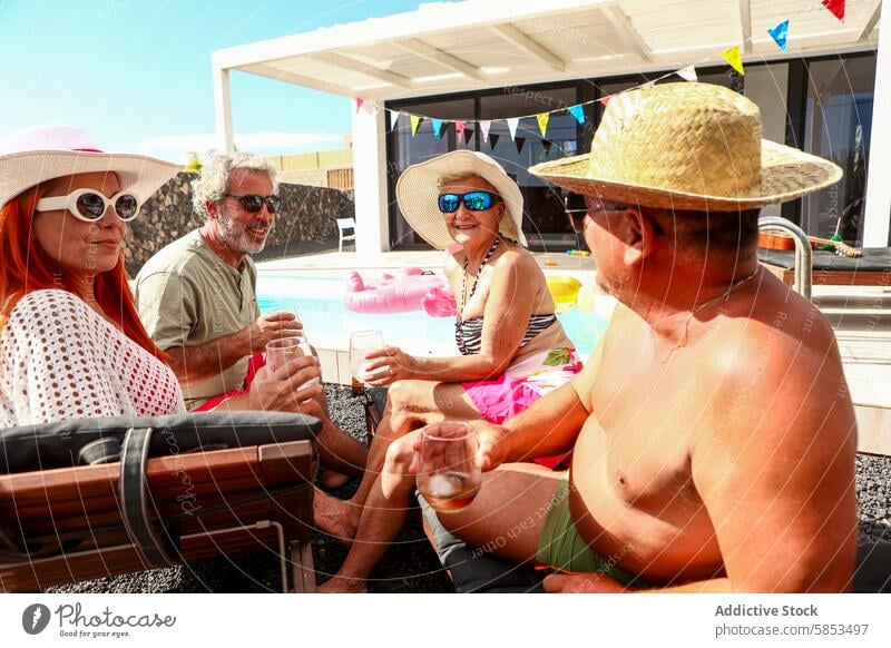 Joyful Seniors Enjoying a Poolside Gathering senior swimming pool fun retirement sun relaxation toast gathering laughter sunglasses hat summer leisure