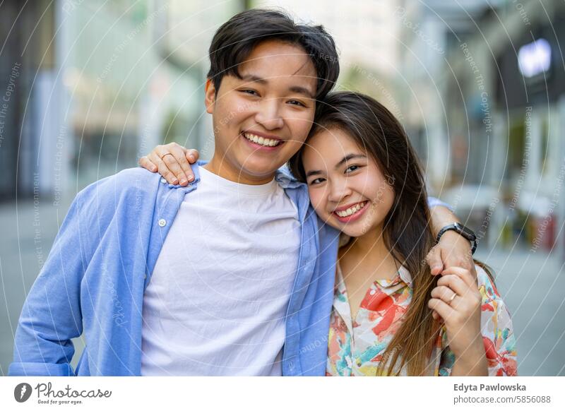 Happy young couple on city street asian real people fun enjoying young adult authentic cheerful confident female happy millennials natural portrait positive