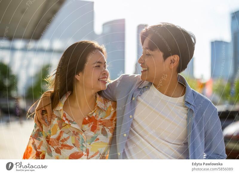 Happy young couple on city street asian real people fun enjoying young adult authentic cheerful confident female happy millennials natural portrait positive