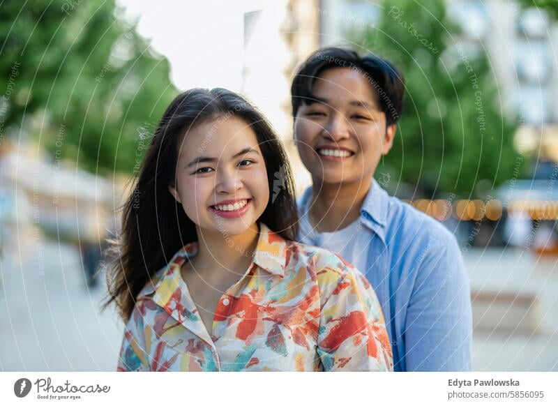 Happy young couple on city street asian real people fun enjoying young adult authentic cheerful confident female happy millennials natural portrait positive