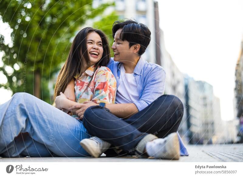 Happy young couple on city street asian real people fun enjoying young adult authentic cheerful confident female happy millennials natural portrait positive