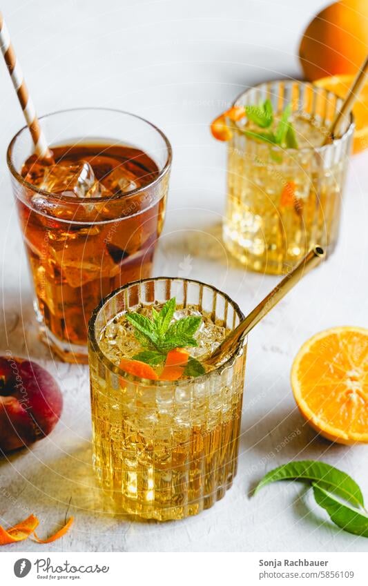 Various drinks with oranges on a gray table. Summer, refreshment. Beverage Cold drink Iced tea Cocktail Longdrink Alcoholic drinks Lemonade Delicious Ice cube