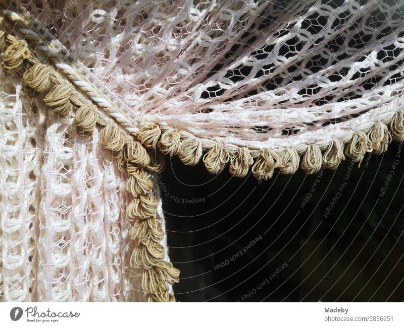 A peaked curtain in the style of the post-war period in the window of the old closed pub in the sunshine in the old town of Oerlinghausen near Bielefeld in the Teutoburg Forest in East Westphalia-Lippe