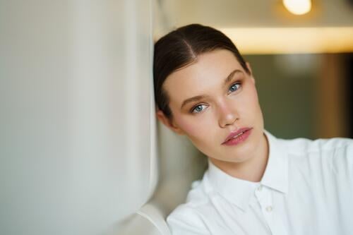 Beauty entrepreneur leaning on a comfortable wall of a cafeteria beauty successful woman young head confident relaxed poised professional ambitious stylish