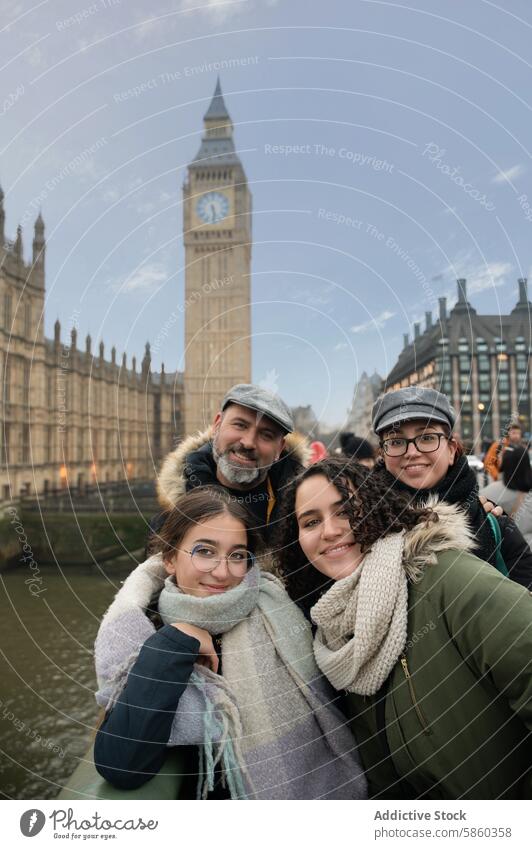 Family enjoying a visit to the London's iconic Big Ben family london big ben travel vacation landmark tourism happiness winter coats scarves togetherness man