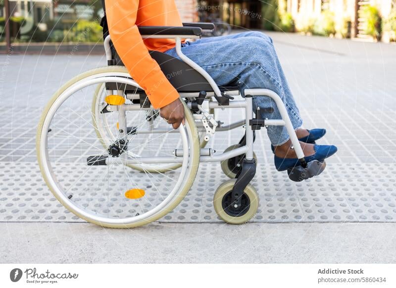 Close-up shot of a black woman in a wheelchair mobility accessibility outdoor business independent ethnic african american pavement close-up young adult female