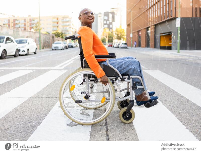 Young black woman in wheelchair crossing urban street smiling confident mobility independence lifestyle city ethnic african american outdoor accessible